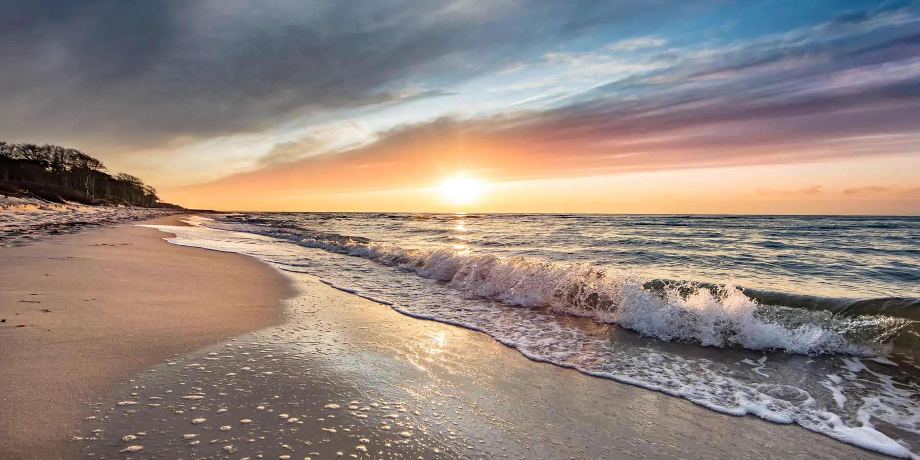 Sonnenaufgang am Ostseestrand mit Blick über Meer und Strand