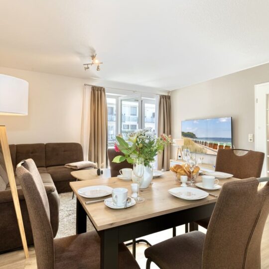Einer von zwei großen Balkonen der Ferienwohnung Helene im Ostseebad Baabe auf der Insel Rügen an der Ostsee nahe Binz - Wohnzimmer, Esstisch und Smart-TV